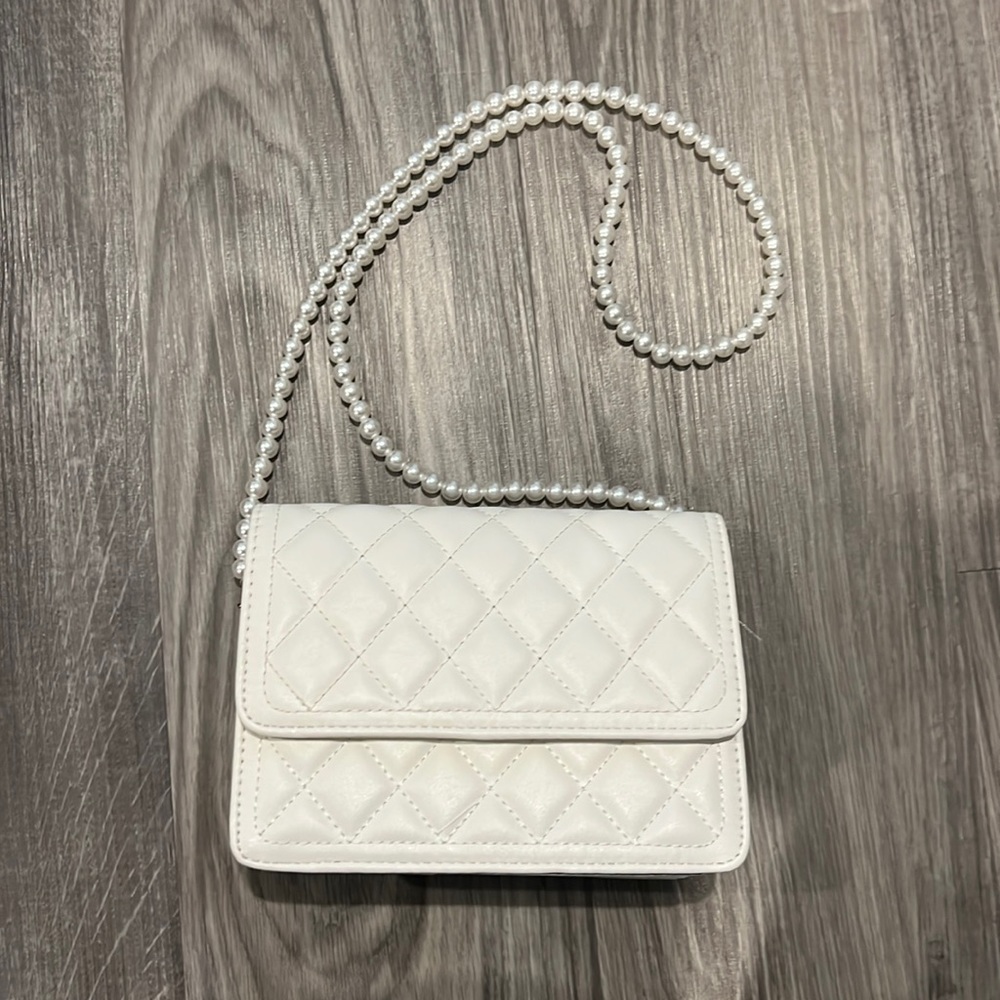 White purse with pearl handle.